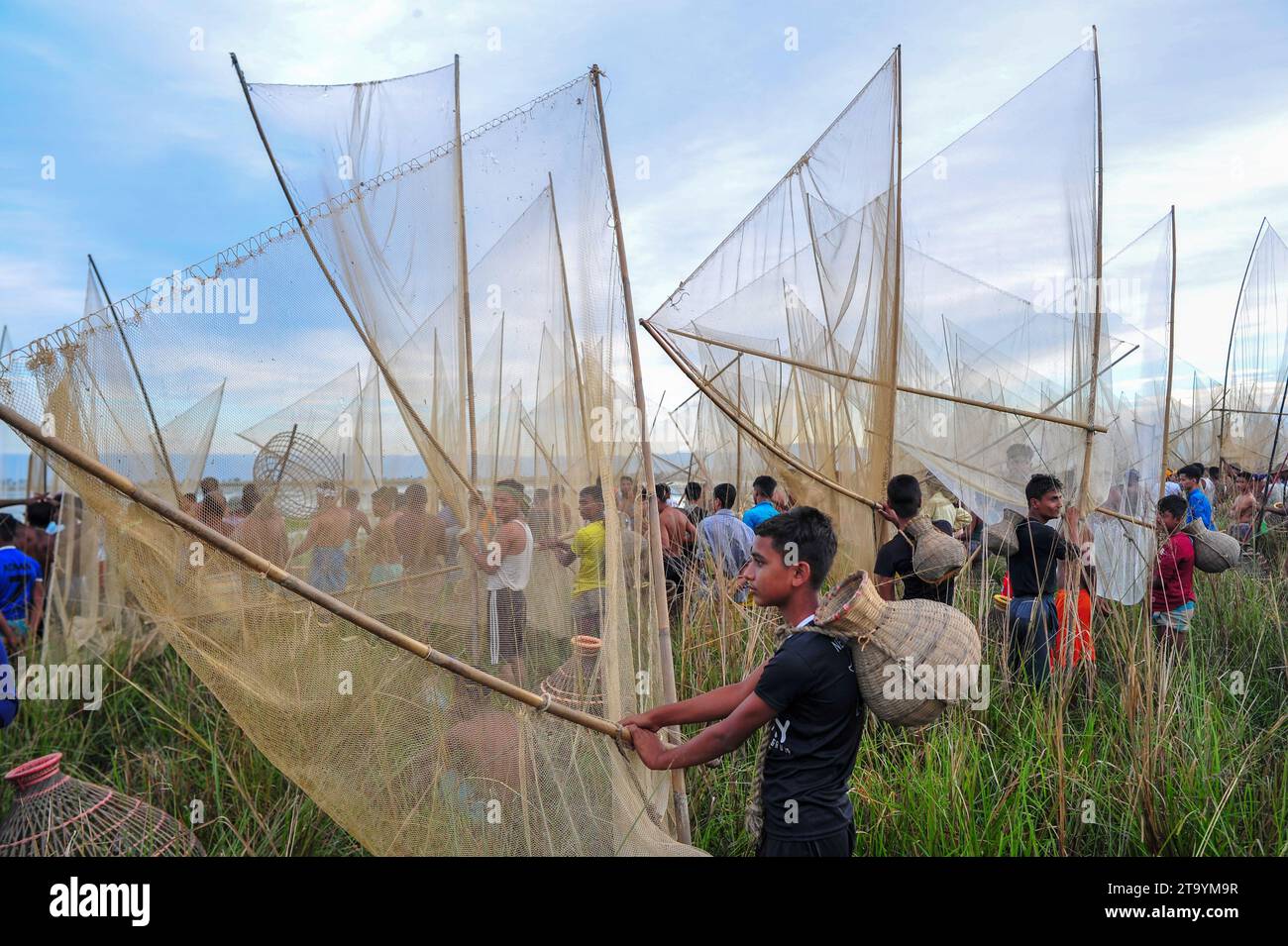 Non esclusiva: 28 novembre 2023 Sylhet-Bangladesh: Le persone rurali armate di trappole di pesce di bambù e rete prendono parte a festeggiare in un inverno di 200 anni f Foto Stock