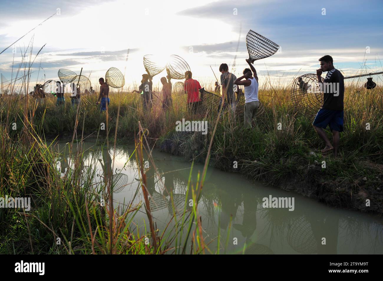 Non esclusiva: 28 novembre 2023 Sylhet-Bangladesh: Le persone rurali armate di trappole di pesce di bambù e rete prendono parte a festeggiare in un inverno di 200 anni f Foto Stock