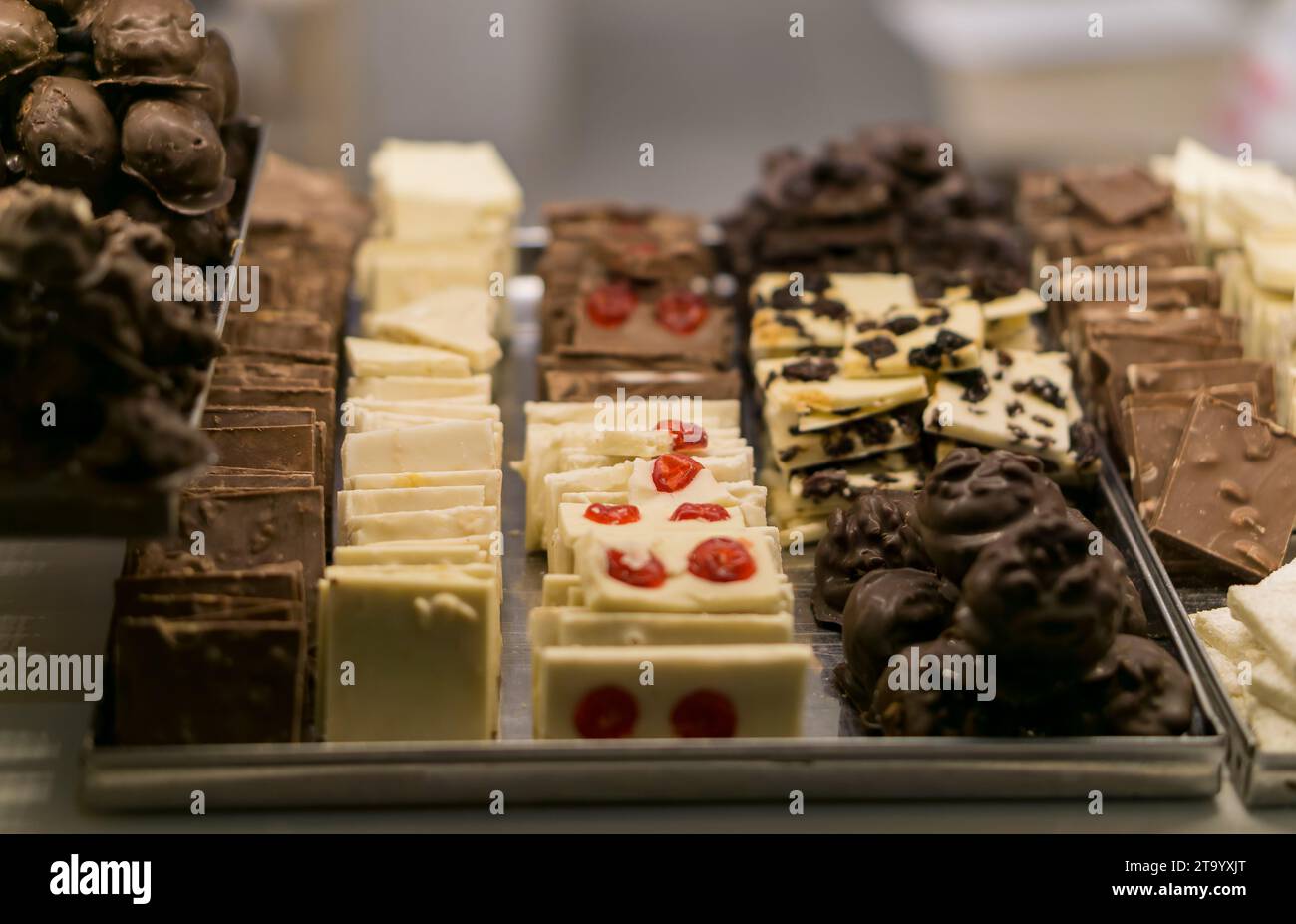 Vari tipi di cioccolatini artigianali esposti nella vetrina del negozio di caramelle. Foto Stock