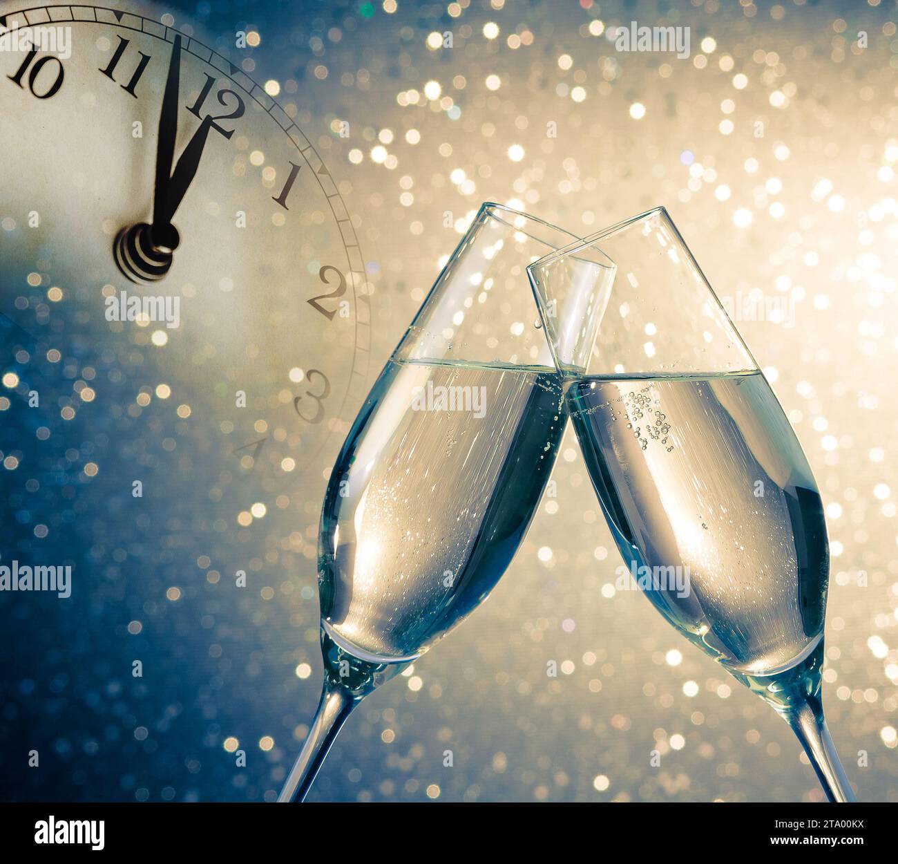 flauti di champagne con bollicine dorate fanno il tifo su sfondo bokeh blu e dorato con sveglia vintage che mostra il concetto di happy new year a mezzogiorno o mezzanotte Foto Stock