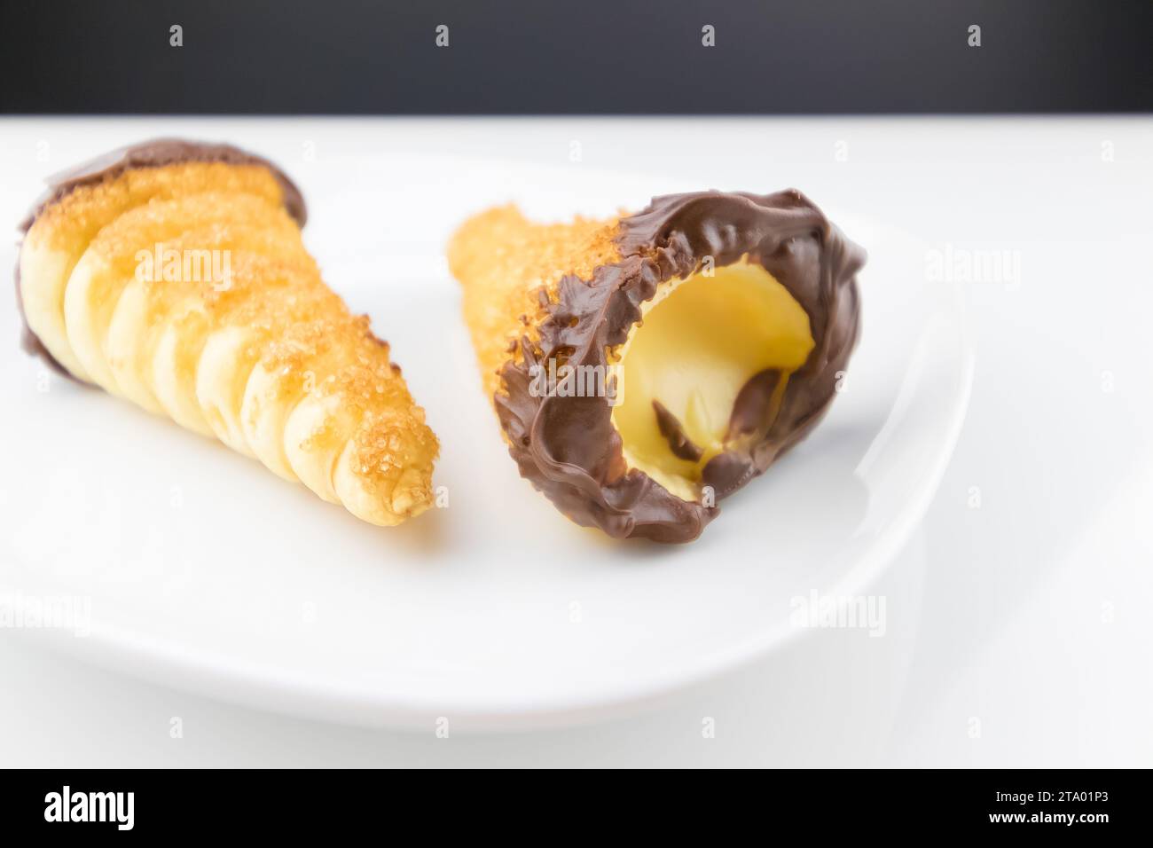 delizioso cannolo siciliano cannellino dolce con pasticceria cioccolato alle nocciole e crema pasticcera, pasta sfoglia italiana su fondo bianco, concetto nutrizionale e dietetico Foto Stock