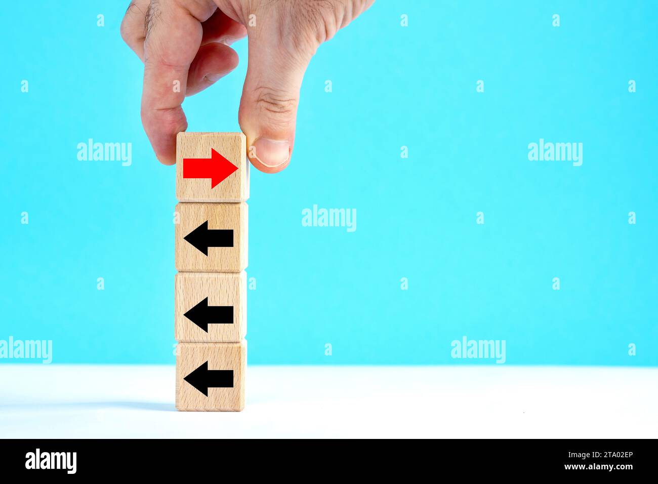 La mano. Cubi di legno con frecce. Superare la crisi dei problemi e il concetto di strada per il successo. invertire la direzione, alternare il concetto di direzione Foto Stock