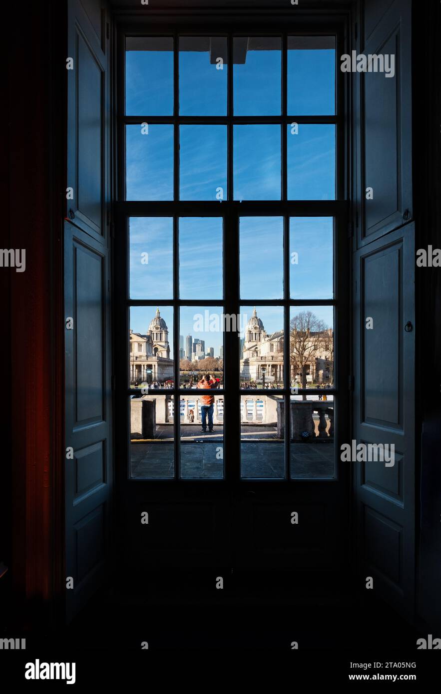 Una vista da una finestra all'interno della Queen's House verso il Royal Naval College Greenwich London. La vista è distorta dai vecchi vetri delle finestre Foto Stock