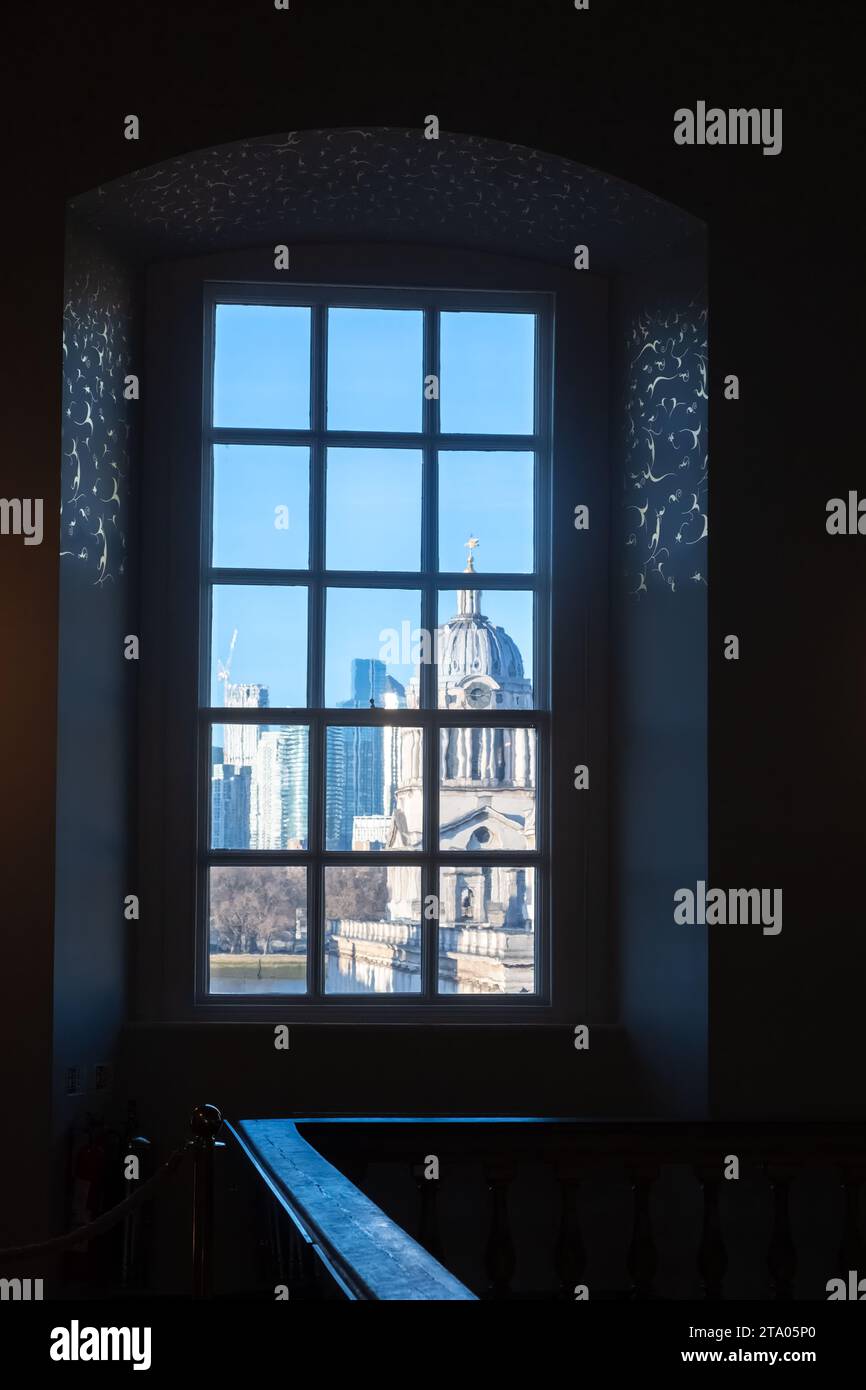 Una vista da una finestra all'interno della Queen's House verso il Royal Naval College Greenwich London. La vista è distorta dai vecchi vetri delle finestre Foto Stock
