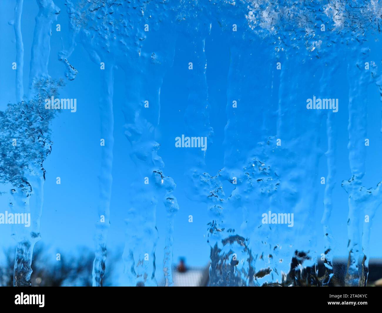 Ghiaccio congelato su una finestra con sfondo blu Foto Stock