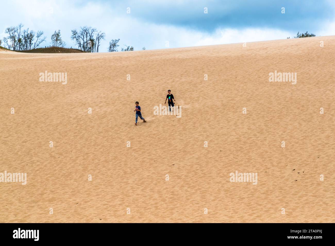 Bambini che corrono lungo una duna di sabbia nel parco nazionale Sleeping Bear, Michigan. Sleeping Bear Dunes National Lakeshore. Glen Arbor Township, Stati Uniti Foto Stock