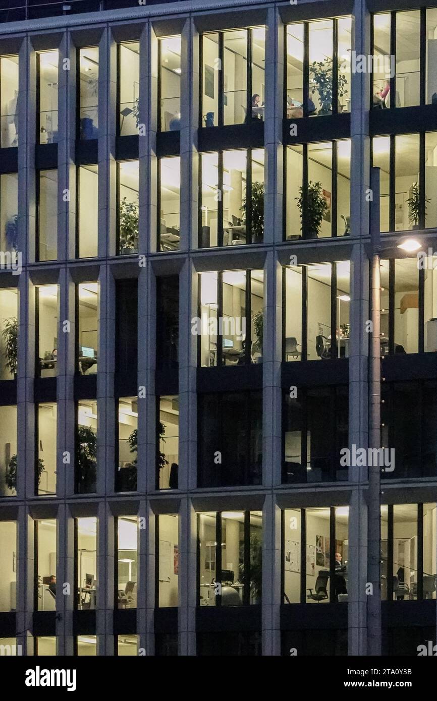 Lipsia, Germania. 27 novembre 2023. Gli uffici in un edificio nel centro della città sono illuminati di sera. Crediti: Jan Woitas/dpa/Alamy Live News Foto Stock