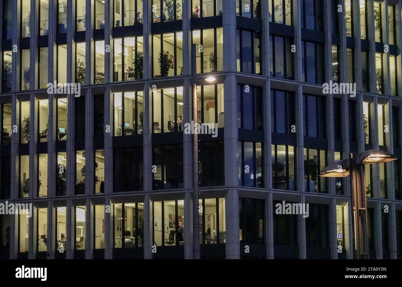 Lipsia, Germania. 27 novembre 2023. Gli uffici in un edificio nel centro della città sono illuminati di sera. Crediti: Jan Woitas/dpa/Alamy Live News Foto Stock