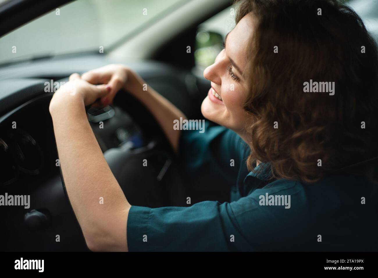 Una donna autista è seduta in macchina. Foto Stock