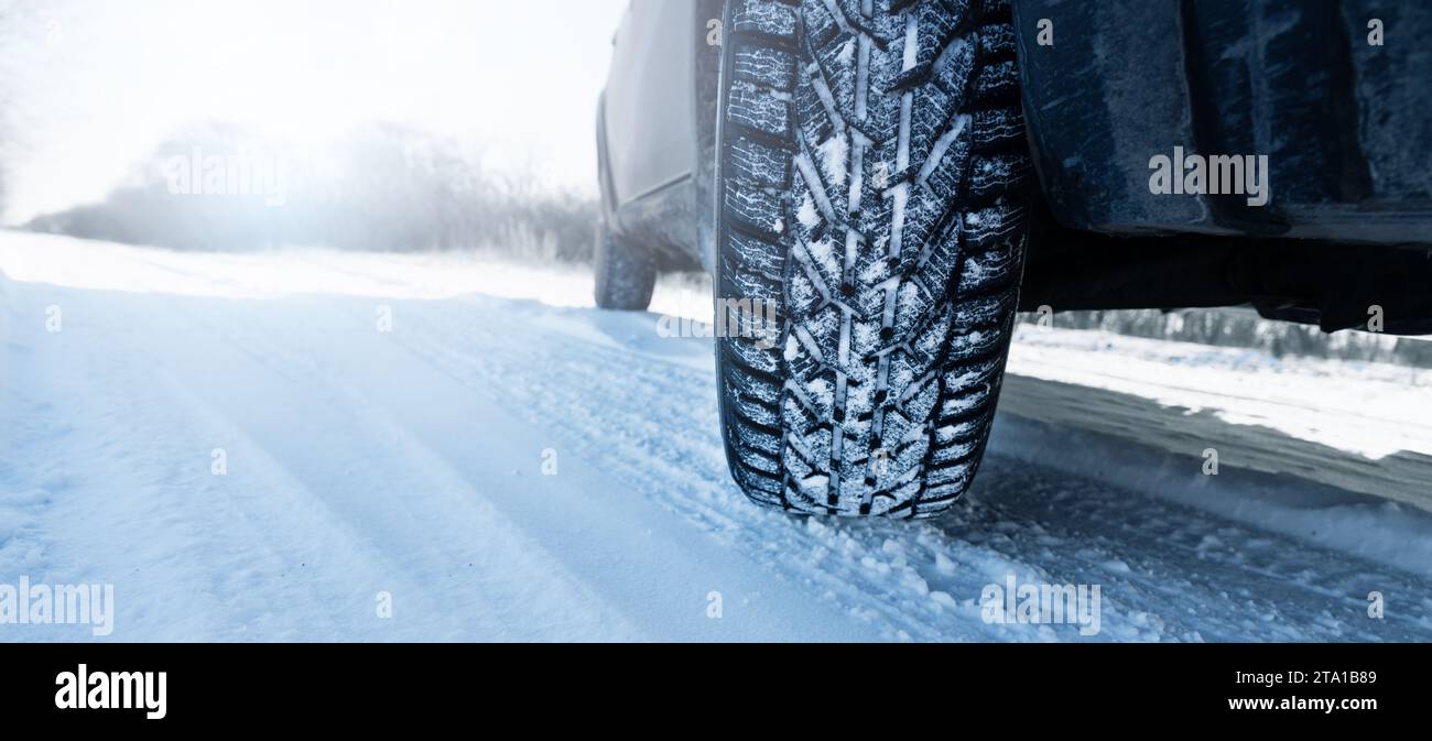 L'auto si trova su una strada invernale ricoperta di neve. Primo piano dello pneumatico invernale. Foto Stock