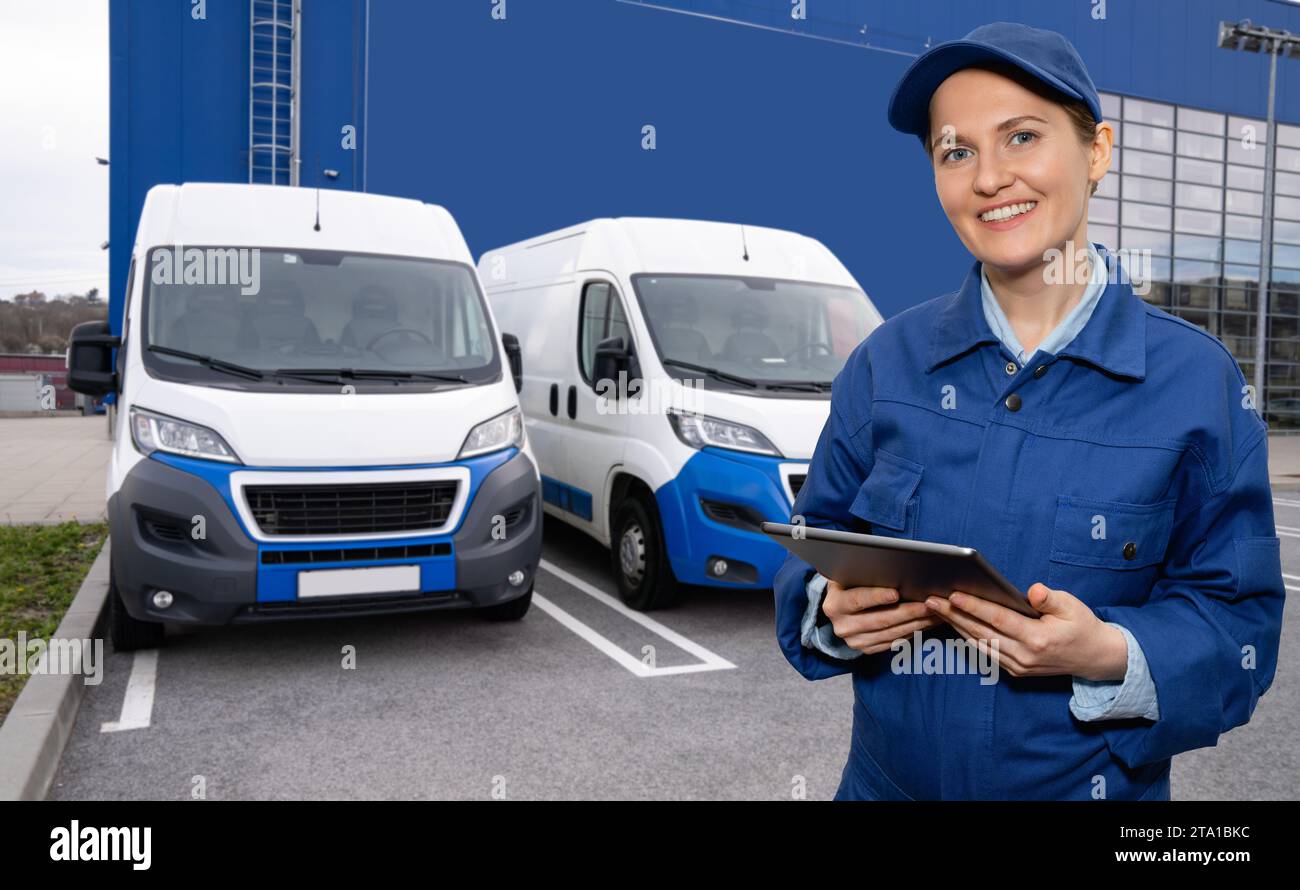 Responsabile donna con un tablet digitale sullo sfondo dei furgoni. Gestione della flotta Foto Stock