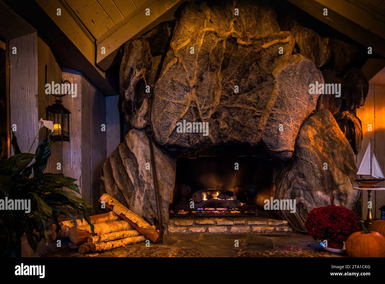 Grande camino in masso nella sala da pranzo principale del Weathervane Terrace Inn & Suites a Charlevoix. L'architetto autodidatta Earl A. Young scoprì la pietra nel 1928 durante lo sviluppo del quartiere Boulder Park della città e la fece nascondere nel bosco per quasi 30 anni prima che fosse dissotterrata per il camino. La tradizione locale vuole che le venature che attraversano la pietra principale traccino la forma del Basso Michigan e delle sue principali autostrade. L'architetto Earl Young costruì case e camini con massi, Charlevoix, Michigan, Stati Uniti. Foto Stock