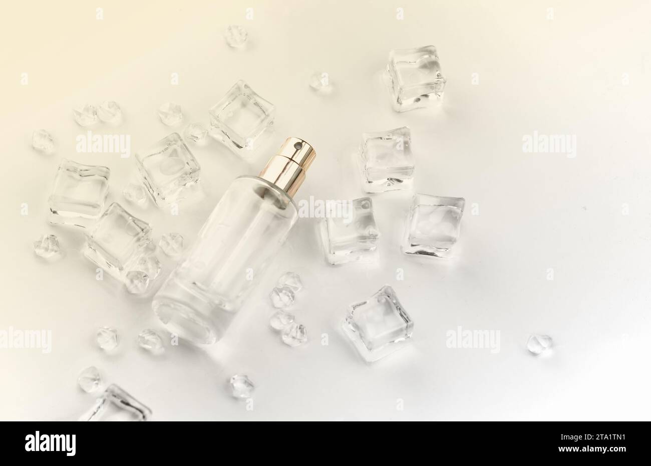 Bottiglia di profumo femminile, fotografia obiettiva di bottiglia di profumo in cubetti di ghiaccio e acqua. Vista dall'alto. Foto prodotto, concetto di freschezza e aroma Foto Stock