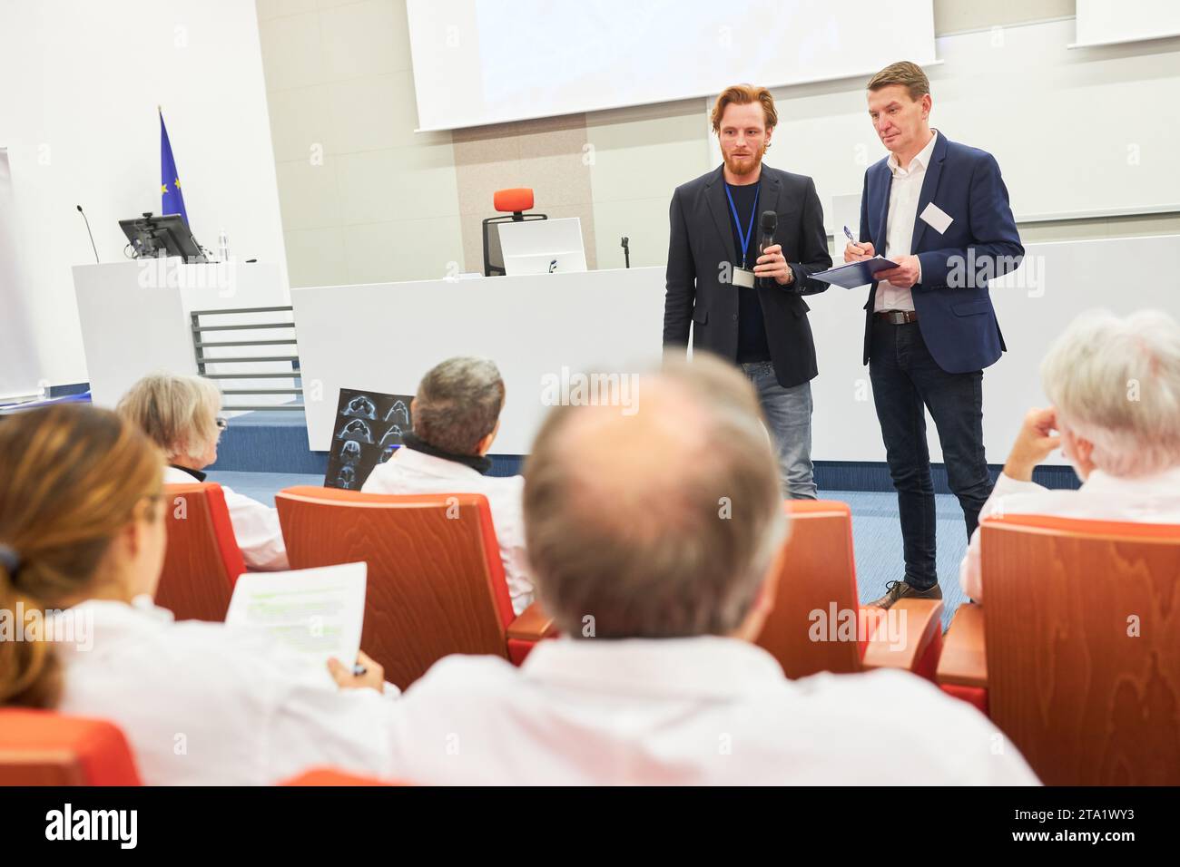 Oratori che discutono con i medici seduti in pubblico in conferenza medica al centro congressi Foto Stock