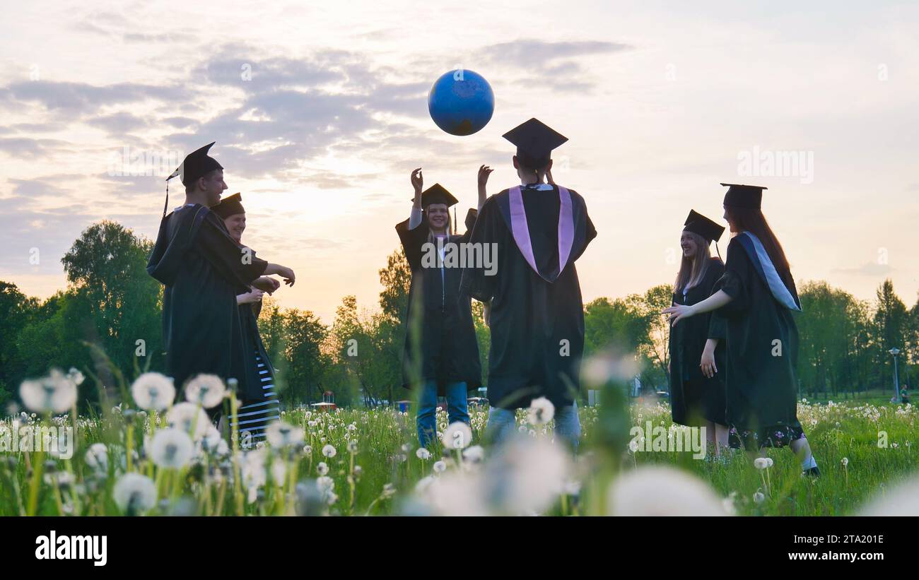 Diplomati in costume che giocano con una palla al tramonto. Foto Stock