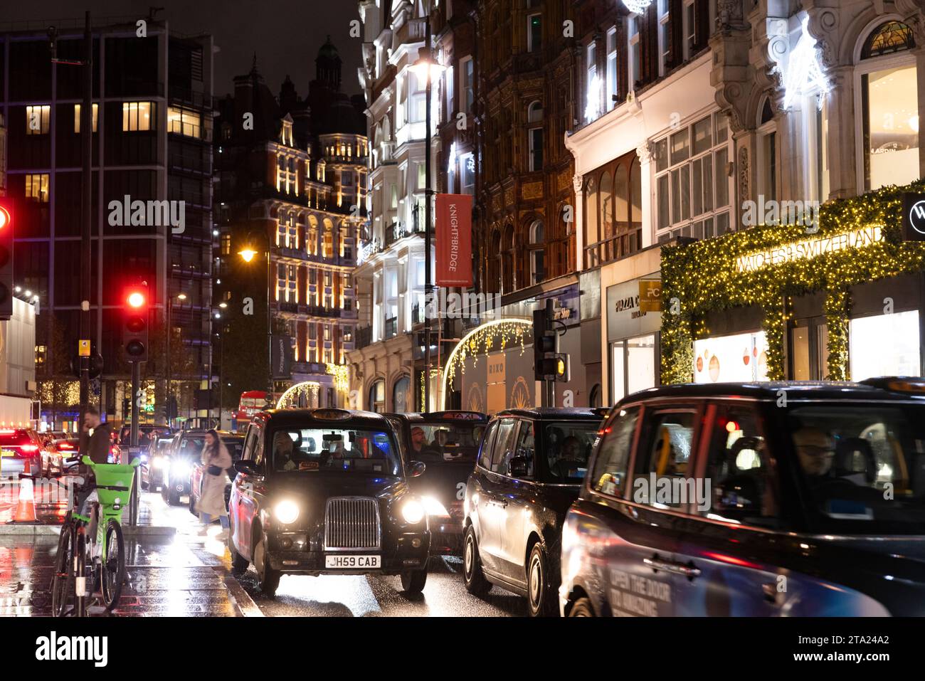 Knightsbridge, una delle zone più lussuose di Londra, in una serata umida durante l'ora di punta, West End di Londra, Inghilterra, Regno Unito Foto Stock