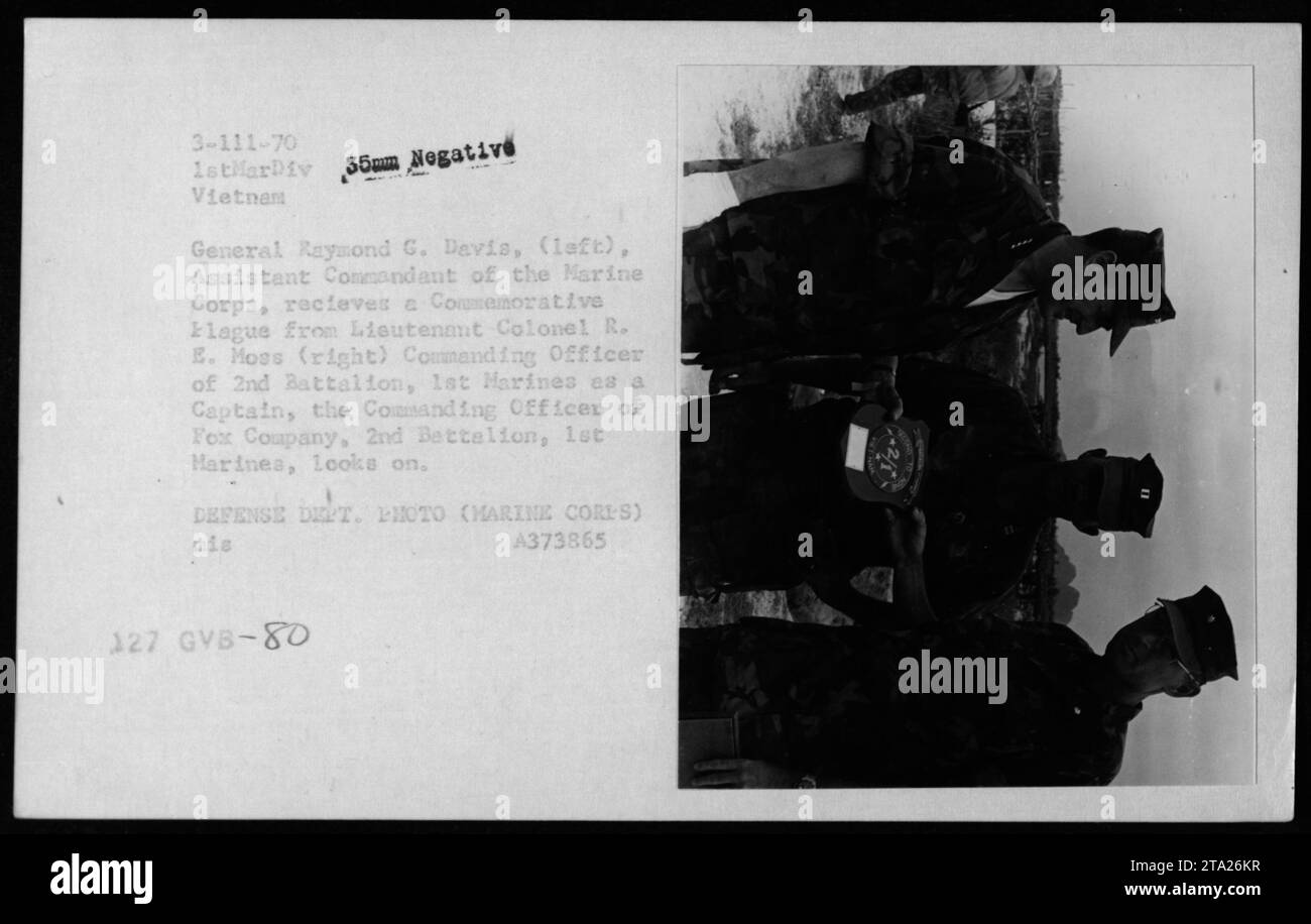 Il generale del corpo dei Marines Raymond G. Davis, Assistente Comandante del corpo dei Marines durante la guerra del Vietnam, è presentato con una targa commemorativa dal tenente colonnello R. E. Moss, ufficiale comandante del 2nd Battalion, 1st Marines. Capitano (nome non menzionato), ufficiale comandante della Fox Company, 2nd Battalion, 1st Marines, è presente anche durante la cerimonia. Foto Stock
