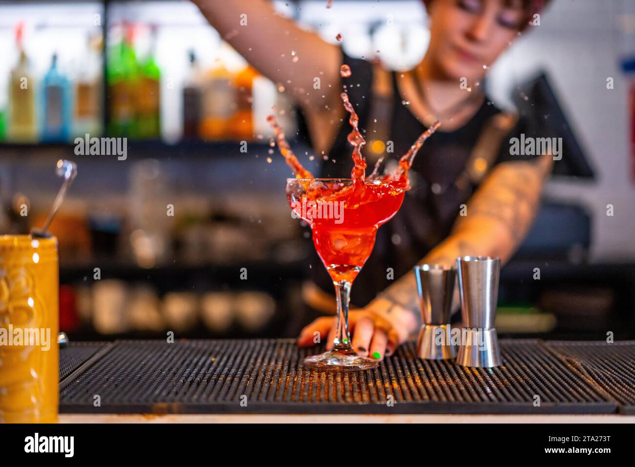 Foto del movimento di un barista che versa e spruzza un cocktail in un bicchiere Foto Stock