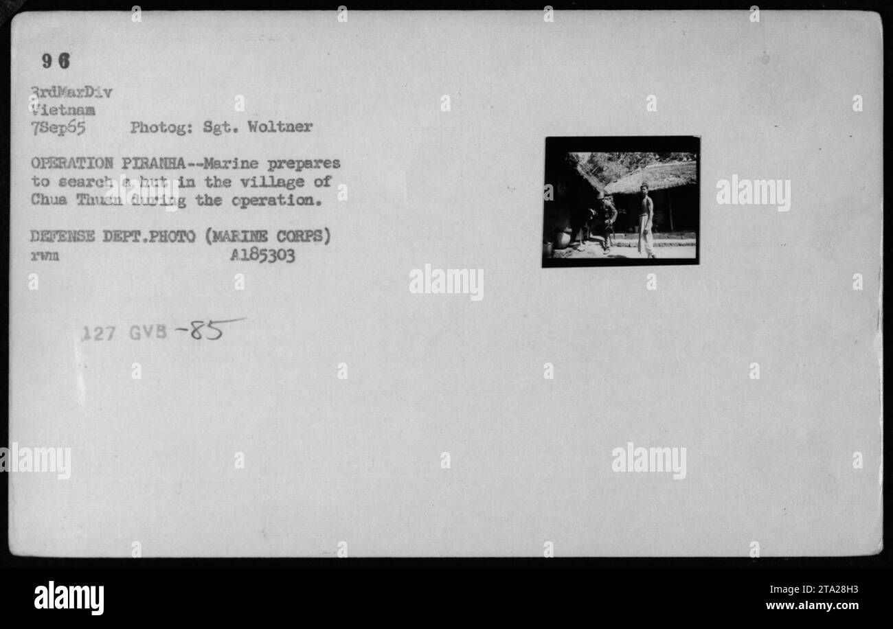 Un Marine si prepara a perquisire una capanna nel villaggio di Chua Thuan durante l'operazione PIRANHA il 7 settembre 1965. Questa foto, scattata dal sergente Woltner, cattura l'intensità del combattimento durante la guerra del Vietnam. Descrive le operazioni militari di ricerca e difesa in Vietnam. (Didascalia fattuale, 50 parole) Foto Stock