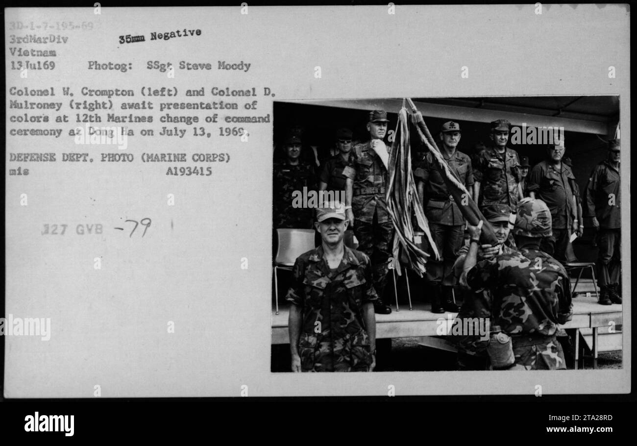 Il colonnello W. Crompton a sinistra e il colonnello D. Mulroney a destra presentano i colori durante la cerimonia di cambio di comando a Dong ha il 13 luglio 1969. Alla cerimonia hanno partecipato l'Assistente Segretario della Marina John Warner, il Segretario alla difesa Melvin Laird e il relatore Dr. Norman Vincent Peale. Il SSgt Steve Moody ha catturato il momento con un negativo di 35 mm. Foto Stock