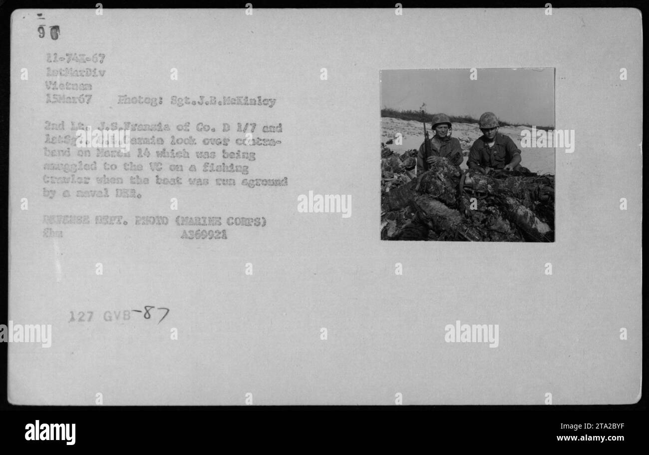 Didascalia: "Fotografia scattata il 15 marzo 1967 durante le attività di combattimento in Vietnam. L'immagine mostra il 2° tenente J.S. Francis of Co. D 1/7 e AstSgt. G.L. Carain sta esaminando un oggetto di contrabbando recuperato da un peschereccio trovato incagliato da un MERCANTE navale. Foto scattata dal sergente J.B. McKinley. Dipartimento della difesa, 2010. Foto Stock