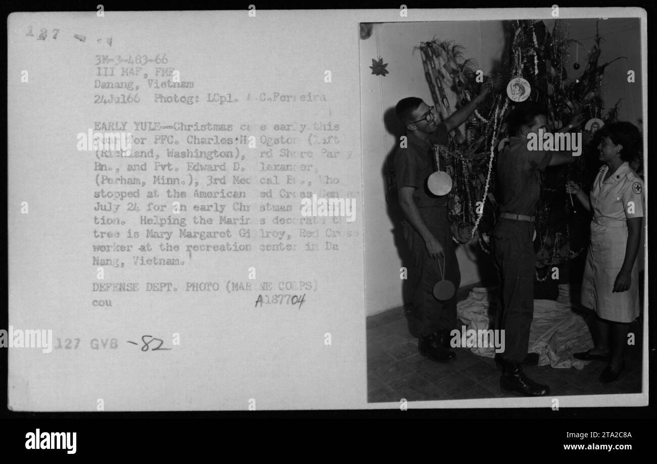 PFC. Charles H. Ogstor e il Pvt. Edward D. Alexander, membri del corpo dei Marines, decorano un albero di Natale presso l'American Red Cross Center a da Nang, Vietnam, il 24 luglio 1966. La prima celebrazione è stata organizzata dall'operatrice della Croce Rossa Mary Margaret Gilroy presso il centro ricreativo." Foto Stock