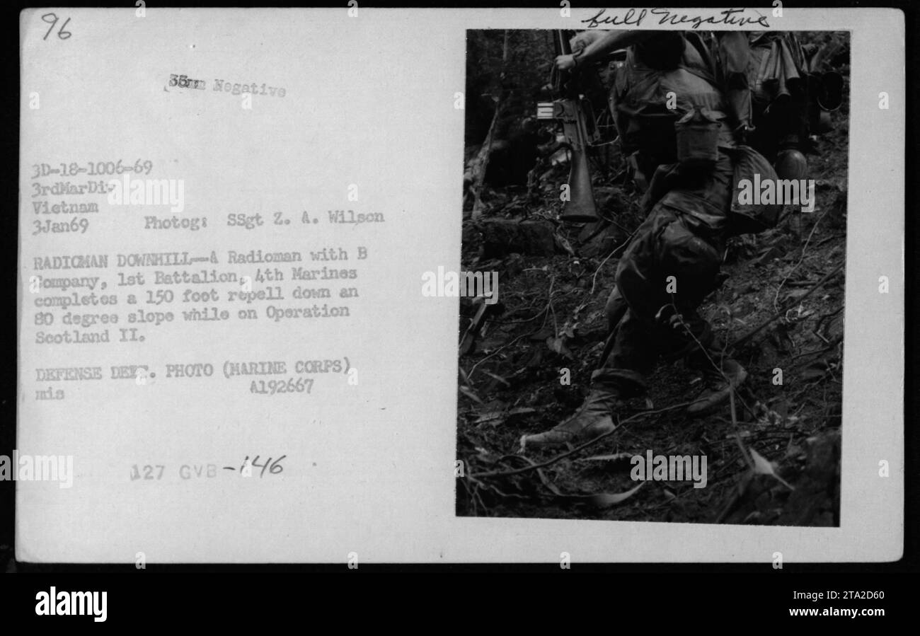 Un radiomano della compagnia B, 1st Battalion, 4th Marines completa una discesa di 150 piedi lungo un pendio di 80 gradi il 3 gennaio 1969, durante l'operazione Scotland II, documentando le operazioni militari americane in Vietnam. Foto Stock
