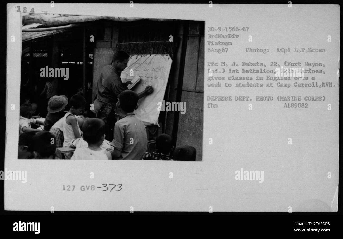 LCpl L.P. Brown offre lezioni di inglese agli studenti di Camp Carroll, Repubblica del Vietnam, il 6 agosto 1967. La fotografia documenta il supporto educativo fornito dal personale militare americano durante la guerra del Vietnam. Foto Stock