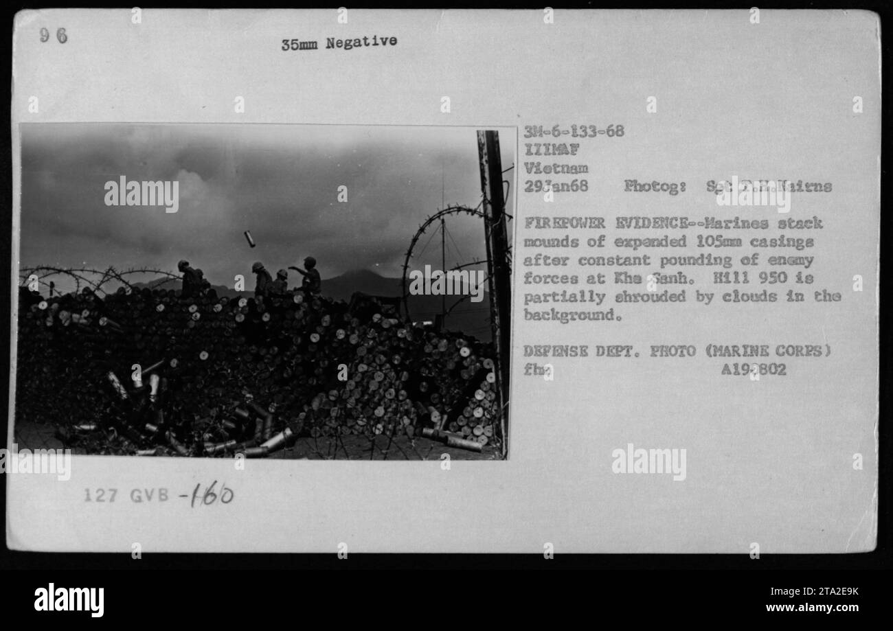 I Marines impilano involucri di artiglieria da 105 mm alla base di combattimento di Khe Sanh il 29 gennaio 1968, come prova di potenza di fuoco. L'H111 950 è parzialmente oscurato dalle nuvole sullo sfondo. La fotografia documenta le attività del corpo dei Marines durante la guerra del Vietnam e riflette le operazioni militari e le condizioni di base. Foto Stock
