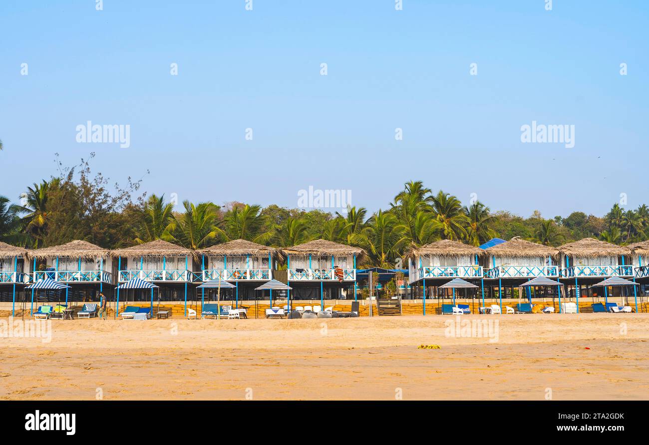 Capanne colorate sulla spiaggia di Agonda con palme a Goa, India Foto Stock