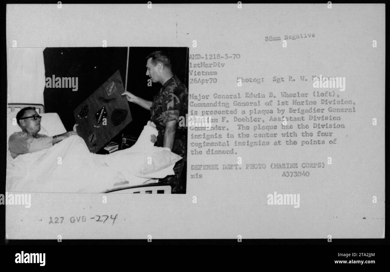 Il maggiore generale Edvin B. Wheeler, comandante generale della 1st Marine Division, riceve una targa dal generale di brigata William F. Doehler, Assistente comandante di divisione, in Vietnam il 26 aprile 1970. La targa riporta le insegne della Divisione al centro e le quattro insegne reggimentali ai punti del diamante. Foto del Dipartimento della difesa del sergente R. W. Nelson. Foto Stock