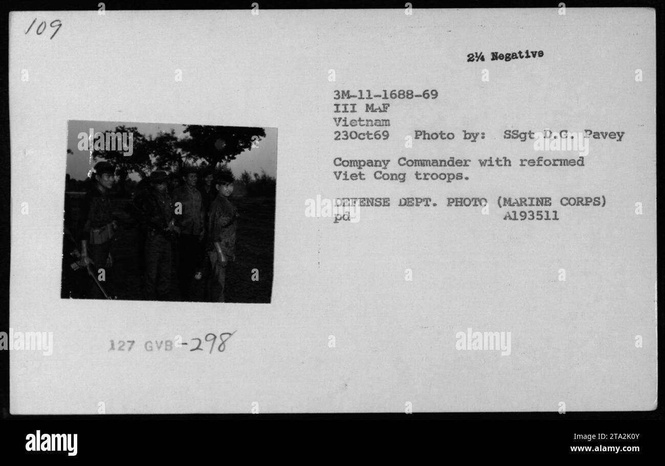 Un comandante della compagnia è visto in questa fotografia, accompagnato da truppe riformate Viet Cong, note anche come Kit Carson Scouts. La foto è stata scattata il 23 ottobre 1969 in Vietnam, durante le attività militari americane. L'immagine è etichettata come GVB-298, parte di una collezione di fotografie scattate dalla SSgt D.G. Pavey e appartiene al Dipartimento della difesa (corpo dei Marines). Foto Stock