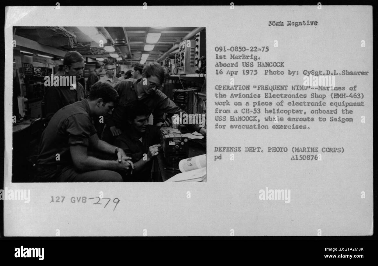 I marines dell'Avionics Electronics Shop di HMH-463 sono visti lavorare su apparecchiature elettroniche di un elicottero CH-53 a bordo della USS HANCOCK durante l'operazione "Frequent Wind" nell'aprile 1975. La foto è stata scattata da CySgt.D.L.Shearer e fa parte di una serie che documenta le attività militari durante la guerra del Vietnam. Foto Stock