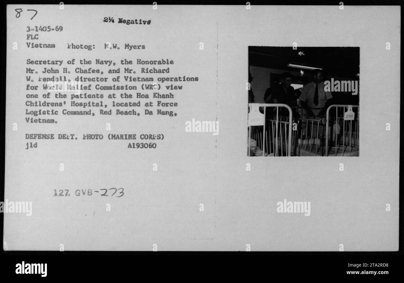 Il Segretario della Marina, John H. Chafee, e Richard W. Rendell, il direttore delle operazioni in Vietnam per la Commissione Mondiale di soccorso (WRC), visitano l'ospedale pediatrico Hoa Khanh a Red Beach, da Nang, Vietnam. Vengono mostrati mentre osservano uno dei pazienti al comando logistico della forza. Foto Stock