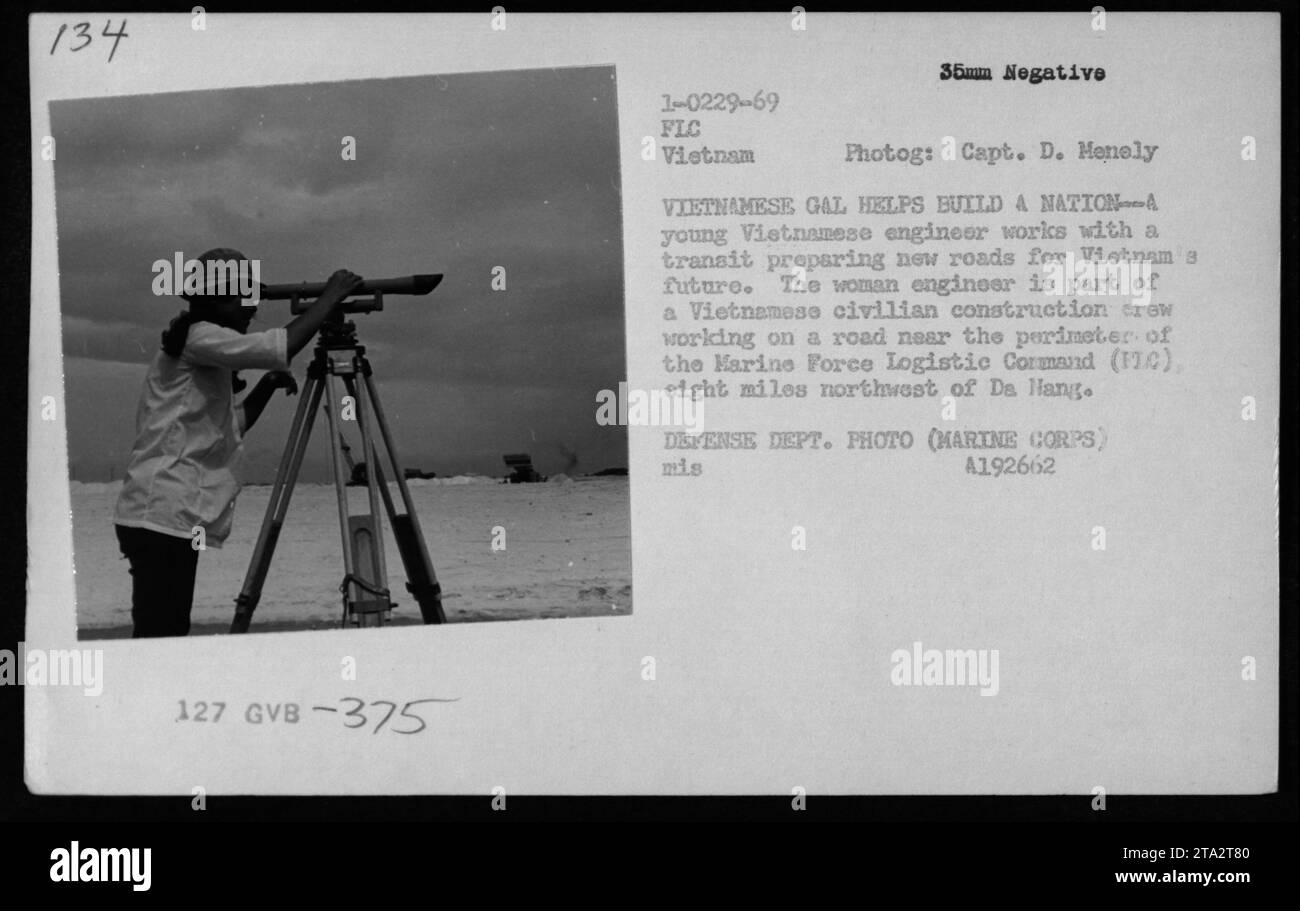 Una donna ingegnere vietnamita aiuta a costruire strade vicino al perimetro del comando logistico della forza Marina a da Nang nel 1969, contribuendo agli sforzi di ricostruzione nazionale. La fotografia documenta l'ingegneria civile e lo sviluppo delle infrastrutture durante la guerra del Vietnam. Foto Stock