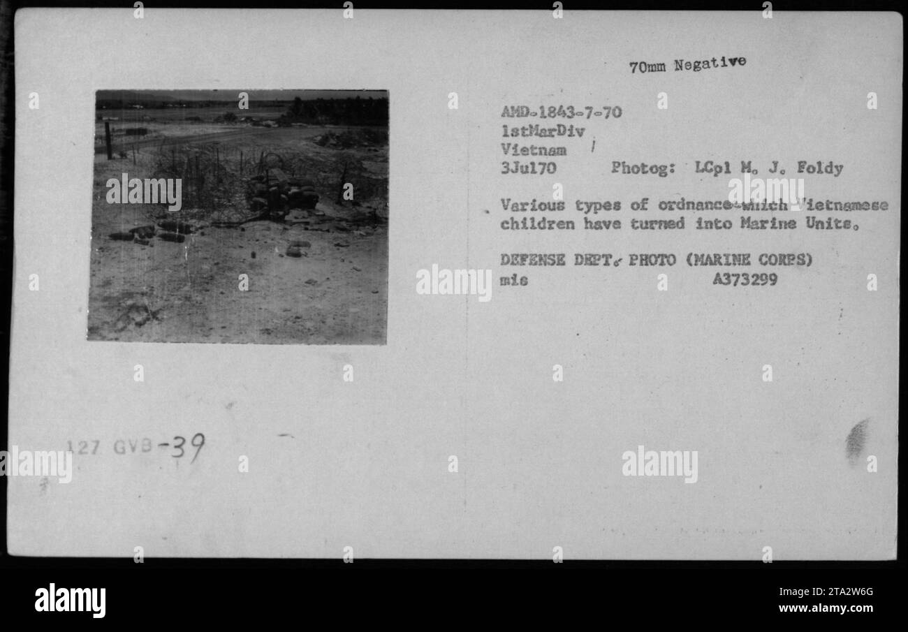 Marines esaminando vari tipi di munizioni raccolte da bambini vietnamiti, desiderosi di aiutare le unità marine di stanza in Vietnam. L'immagine cattura il processo di carico e scarico di diversi tipi di munizioni, mostrando il variegato arsenale utilizzato durante la guerra. 3 luglio 1970. Foto Stock
