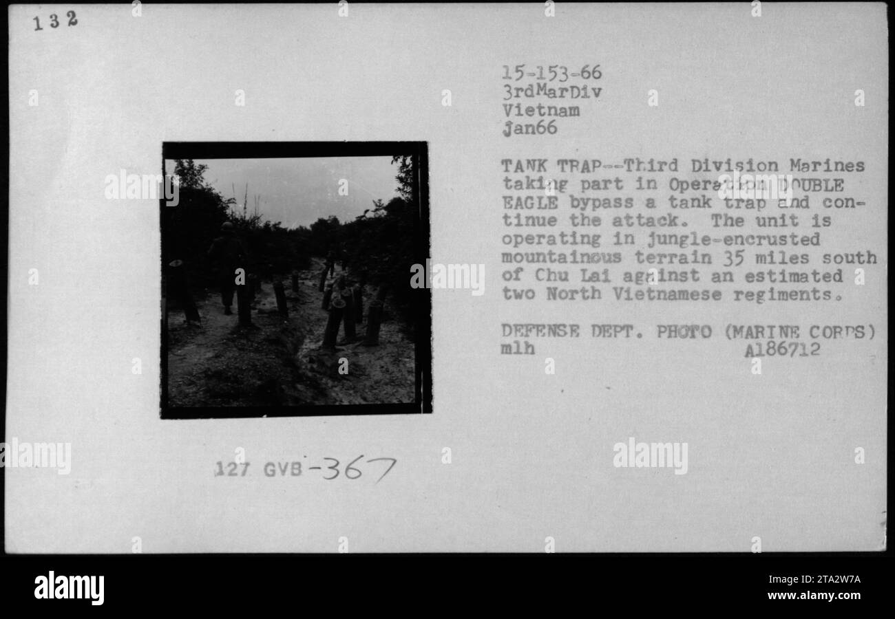 I Marines della terza Divisione navigano oltre una trappola di carri armati attraverso montagne coperte di giungla, 35 miglia a sud di Chu Lai, durante l'operazione DOUBLE EAGLE nel gennaio 1966. La fotografia mostra le truppe americane che ingaggiano reggimenti nordvietnamiti in Vietnam durante la guerra del Vietnam. Foto Stock