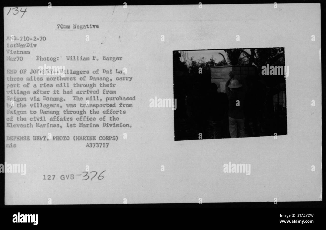 Gli abitanti del villaggio a dai la trasportano una riseria attraverso il loro villaggio dopo che è stata trasportata da Saigon a Danang. Il mulino fu acquistato dagli abitanti del villaggio e consegnato con l'aiuto dell'ufficio affari civili dell'Eleventh Marinas, 1st Marine Division. Foto di William P. Barger. Foto Stock