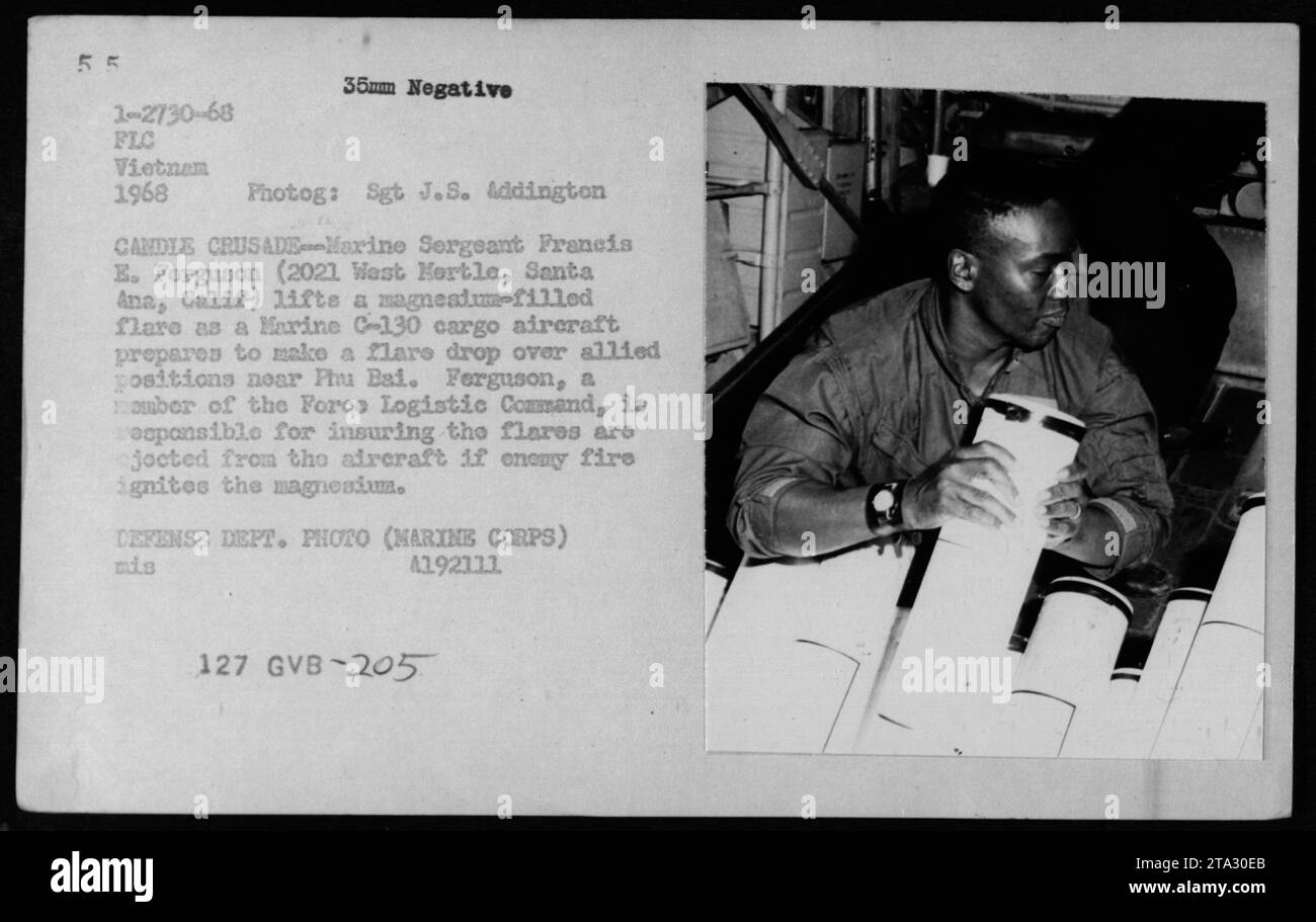 Il sergente marino Francis E. Ferguson si prepara a sollevare un bagliore pieno di magnesio mentre un aereo da carico C-130 del Marine si prepara a fare un salto sopra le posizioni alleate vicino a Phu Bai durante la guerra del Vietnam. Ferguson è responsabile dell'espulsione dei razzi dall'aereo se il fuoco nemico accende il magnesio. Questa foto è stata scattata dal sergente J.S. Addington, un membro del comando logistico della forza, nel 1968. Foto Stock