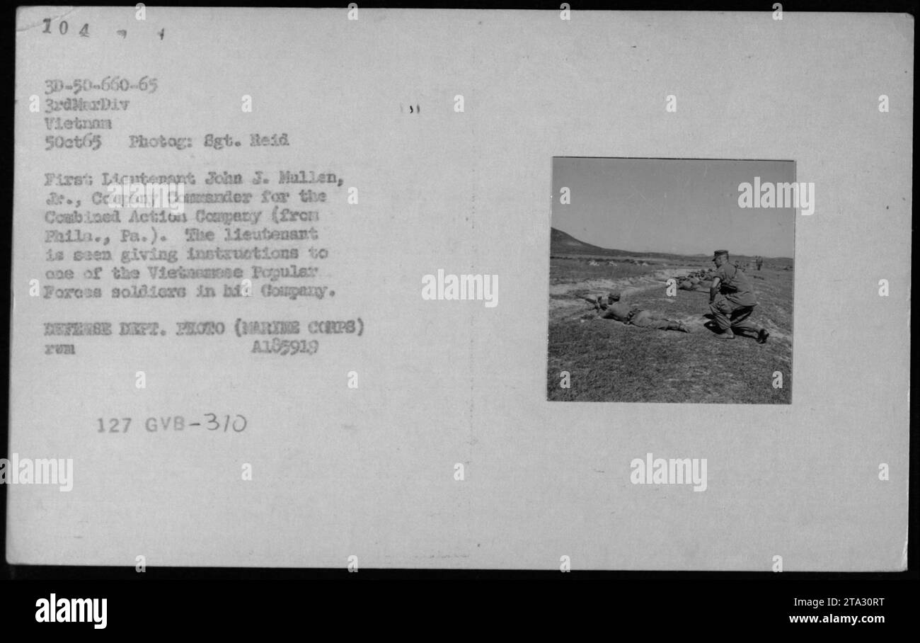 Primo tenente John J. Mullen, 3., Comandante della compagnia per la Combined Action Company (originaria di Filadelfia, Pa.) dando istruzioni a un membro dei soldati delle forze popolari vietnamite nella sua compagnia. Le didascalie della fotografia sono dettagli dall'ARVN (esercito della Repubblica del Vietnam) - 5 ottobre 1965. DIPARTIMENTO DIFESA FOTO (ARTE CORPS) A185919 PUM 127 GVB-3/0 Foto Stock