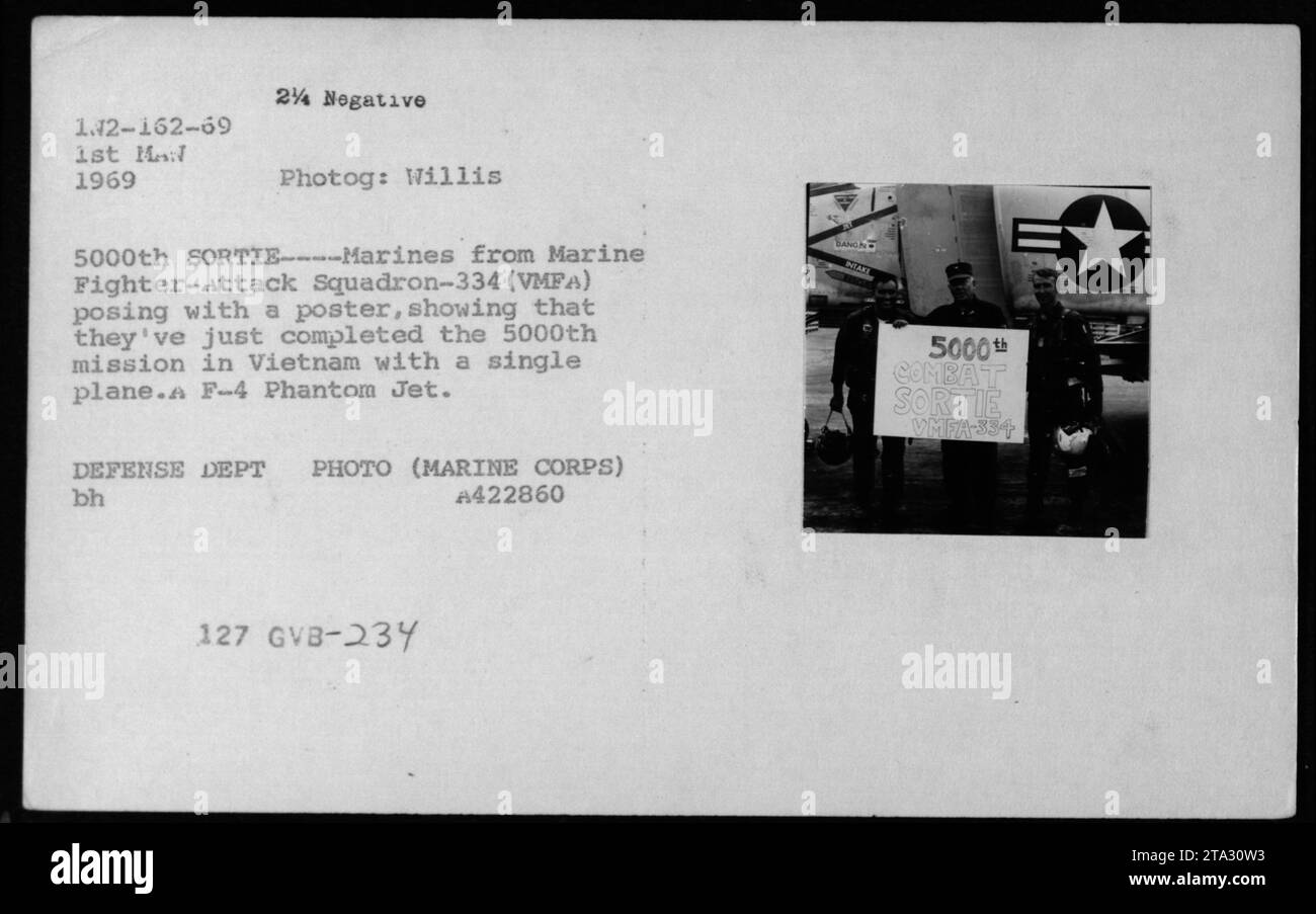 I marines del VMFA-334 celebrano il completamento della loro 5000a missione in Vietnam con un F-4 Phantom jet nel 1969, in posa con un poster commemorativo. Foto Stock