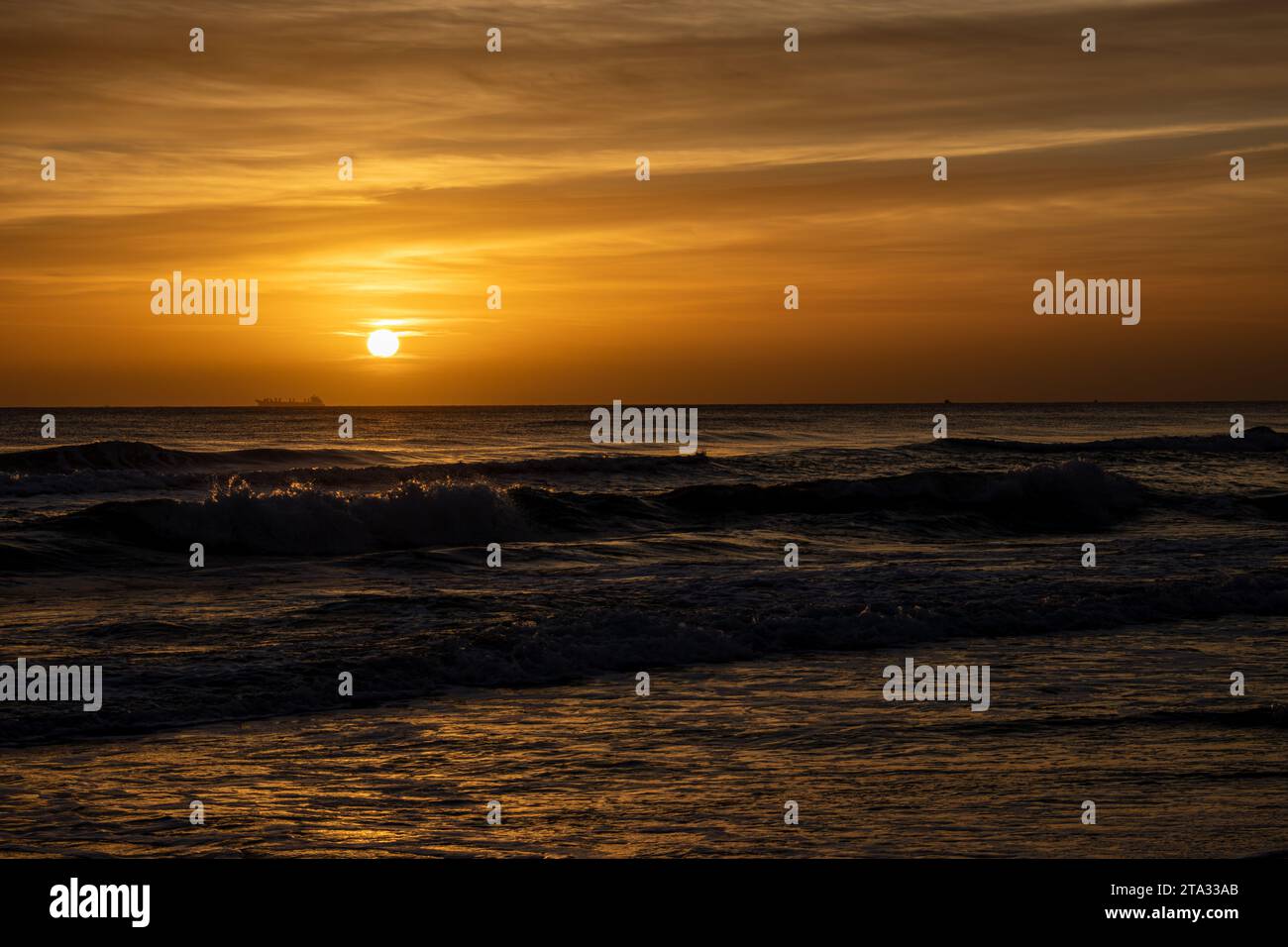 Alba sul Mediterraneo a Miramar, Spagna, con una nave visibile all'orizzonte Foto Stock