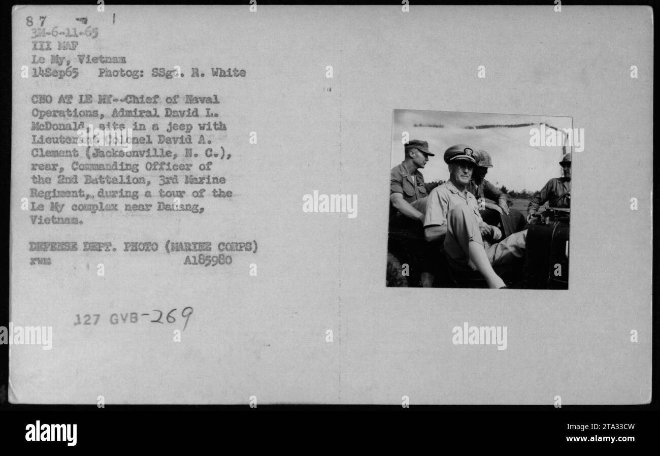 Seduto su una jeep, capo delle operazioni navali, ammiraglio. David L. McDonald, è accompagnato dal tenente colonnello David A. Clement, comandante del 2nd Battalion, 3rd Marine Regiment, durante la loro visita al complesso le My vicino Danang, in Vietnam. 14 settembre 1965." Foto Stock