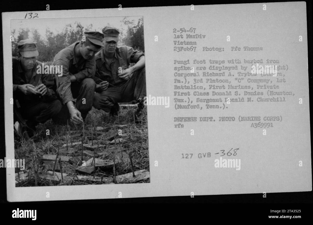Il 23 febbraio 1967, il caporale dei Marines degli Stati Uniti Richard A. Trybua, il soldato Donald S. Donies e il sergente Donald M. Churchill espongono trappole vietnamite con punte di ferro spinato durante la guerra del Vietnam, documentando le armi nemiche e le attività militari. Foto Stock