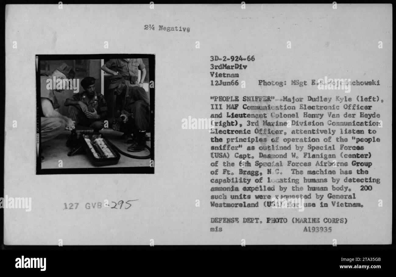 "Il maggiore Dudley Kyle (a sinistra) e il tenente colonnello Henry Van der Heyde (a destra) ascoltano il capitano delle forze speciali Desmond Flanigan (al centro) mentre spiega il funzionamento della macchina "People sniffer". La macchina utilizza il rilevamento dell'ammoniaca per individuare gli esseri umani ed è stato richiesto dal generale Westmoreland per l'uso in Vietnam. Fotografia scattata il 12 giugno 1966 da MSgt E.R. Wojciechowski." Foto Stock