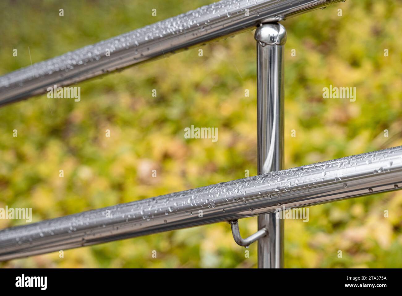 corrimano in metallo con gocce di pioggia, tiro con profondità di campo ridotta. ringhiere in metallo. Foto Stock