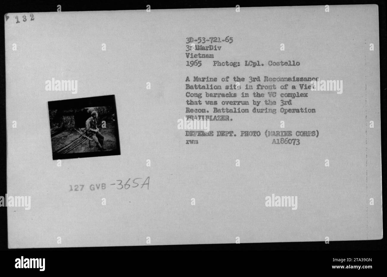 Nel 1965, un Marine del 3rd Reconnaissance Battalion si sedette di fronte ad una caserma dei Viet Cong nel complesso VC invaso durante l'operazione TRAILBLAZER nella guerra del Vietnam. Foto Stock