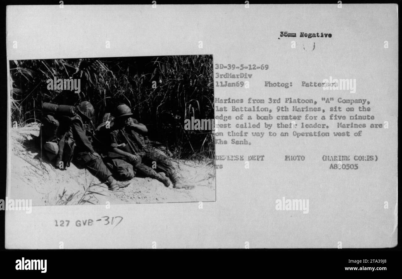 I marines del 3rd Platoon, una compagnia, 1st Battalion, 9th Marines si riposano di cinque minuti l'11 gennaio 1969 in un cratere bomba mentre si muovono verso un'operazione ad ovest di Khe Sanh, Vietnam. Foto Stock