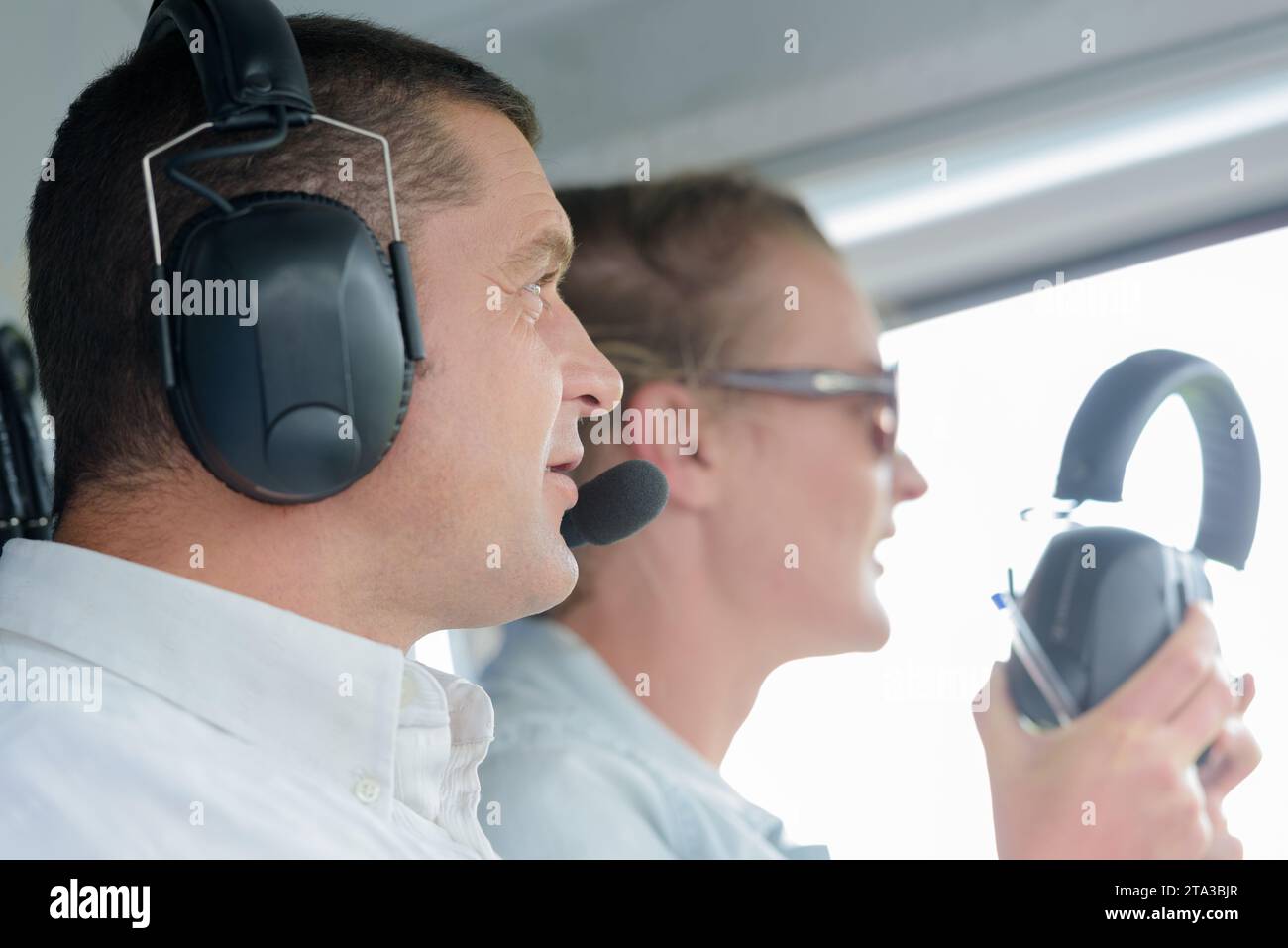 vista ravvicinata del pilota che indossa una cuffia con accompagnamento femminile Foto Stock