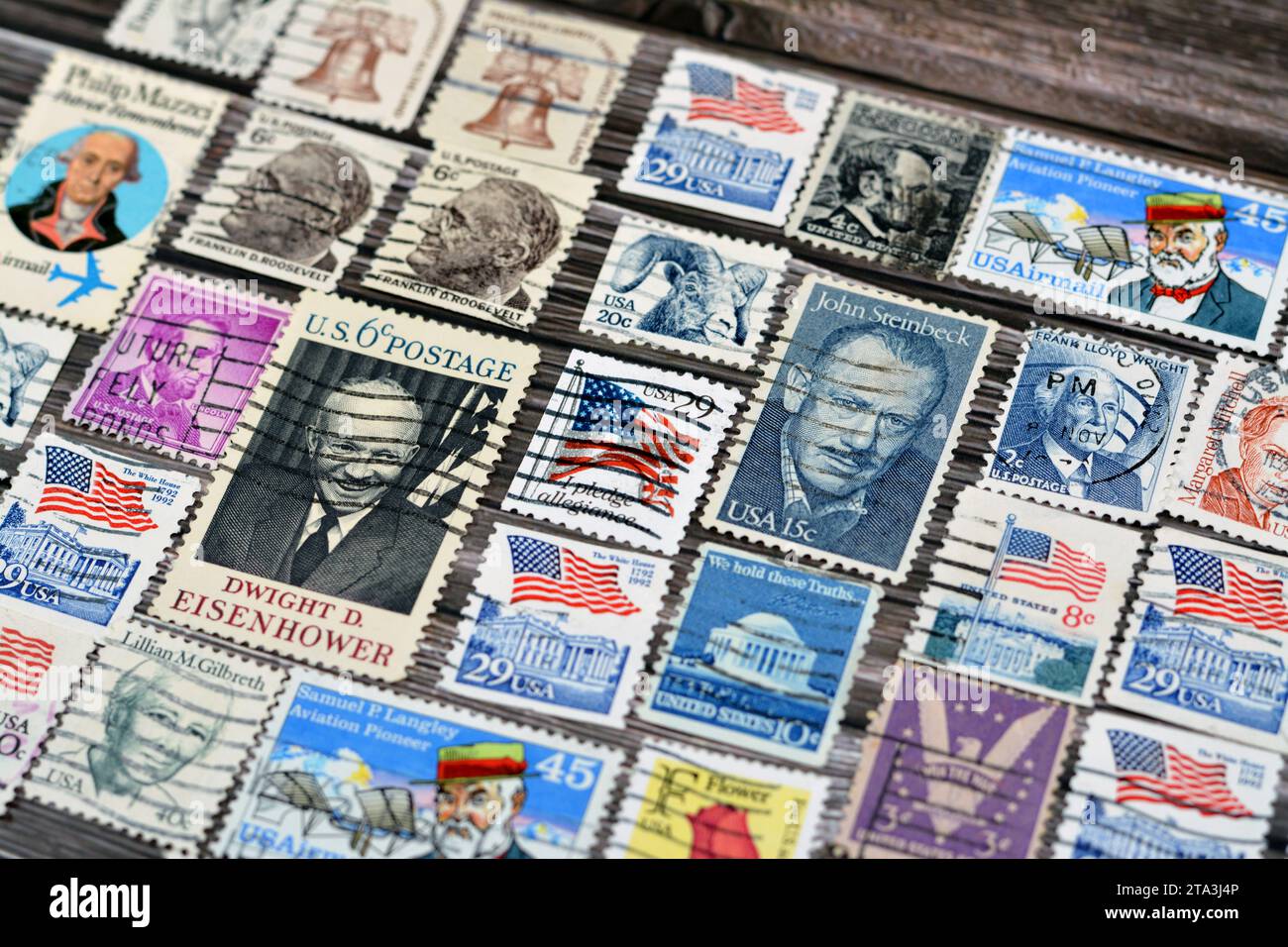 Cairo, Egitto 21 settembre 2022: Vari vecchi francobolli usati dagli Stati Uniti d'America in tempi diversi su uno sfondo di legno, con una copertina Foto Stock